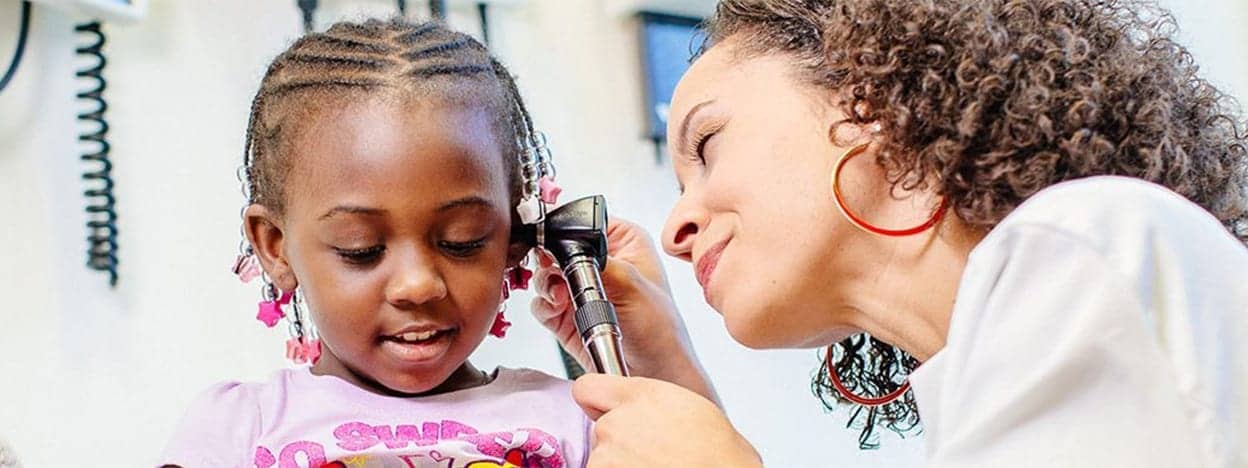 Healthcare provider examining a child’s ear with an otoscope