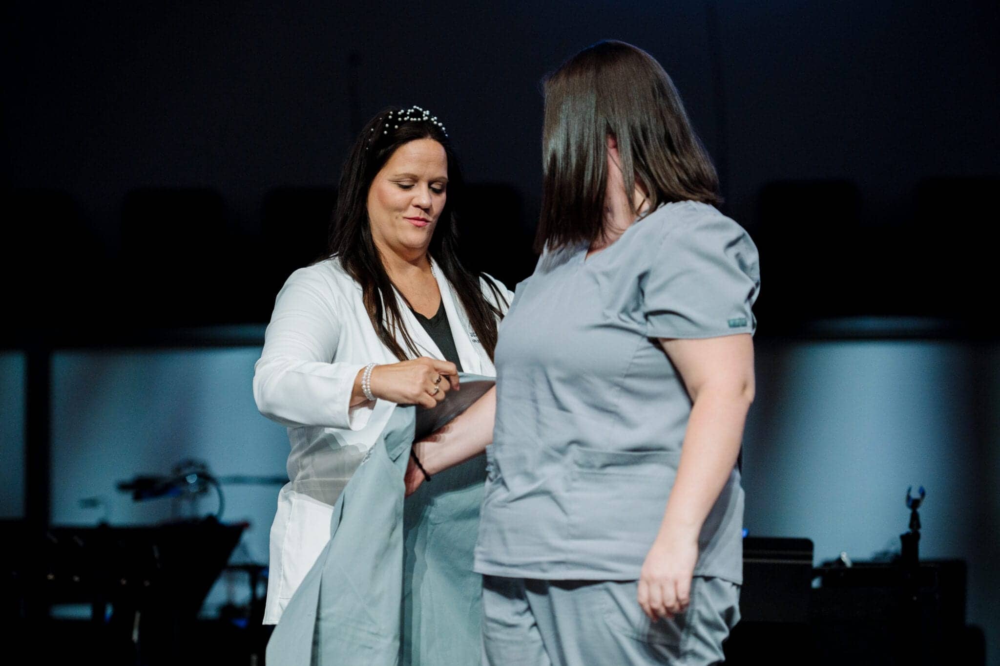 Nursing student putting on clinical coat