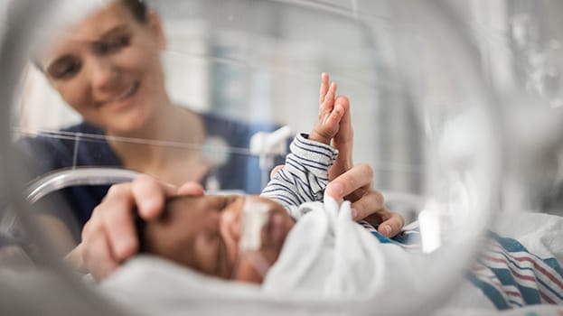 Nurse checking on a baby in the NICU