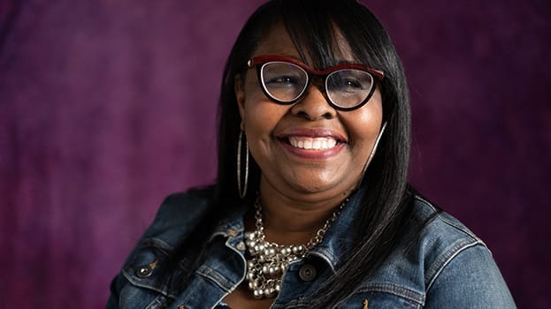 Woman smiling with a purple backdrop